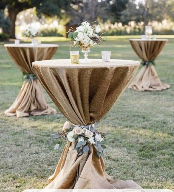 Tables mange-debout habillées et décorées pour un cocktail de mariage en extérieur au Domaine La Rimbertière, dans la Vienne.